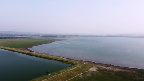Aerial-view-shot-of-Landscape-at-the-end-of-Pa-Sak-Jolasid-Dam-with-green-grass-and-water