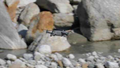 Drone-flying-forward-low-to-ground-river-stream,-tracking-shot-closeup,-day