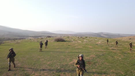 Soldiers-walking-in-formation-on-the-field,-aerial-view