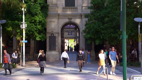 Beautiful-archway-of-heritage-listed-GPO-laneway-building,-people-crossing-the-crosswalk-on-Queen-street,-downtown-Brisbane-city,-central-business-district,-static-shot