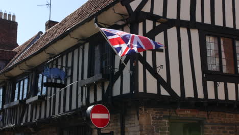 Ein-Alter-Britischer-Tudor-Pub-Mit-Bar-Eingangstür-Und-Union-Jack-Flagge,-Die-Draußen-Weht