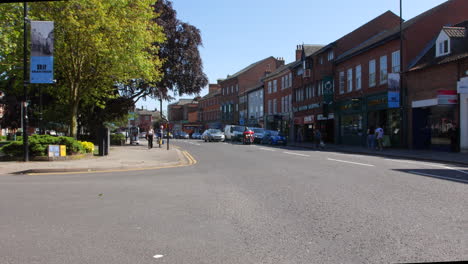 Die-Hauptstraße-Im-Stadtzentrum-Von-Grantham-Im-Sommer-Mit-Verkehr,-Der-An-Geschäften-Vorbeifährt,-Und-Menschen,-Die-In-England-Spazieren-Gehen