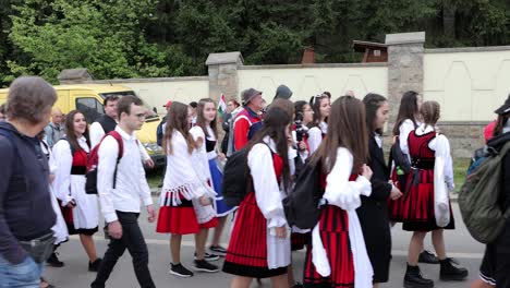 Pilgrims,-some-in-traditional-costume,-walk-past-camera-on-Csíksomlyó-Pilgrimage