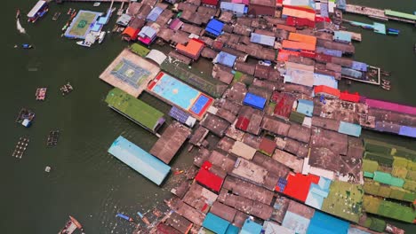 Vista-Aérea-De-La-Aldea-Flotante-De-Panyee-En-La-Que-Se-Ven-Coloridos-Edificios-Y-Un-Campo-De-Deportes-Flotando-En-El-Agua-Y-También-Se-Ven-Paneles-Solares,-Lo-Cual-Es-Increíble-En-El-Parque-Nacional-De-Phang-Nga-En-Tailandia.