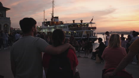 Ein-Hübsches-Paar-Beobachtet-Bei-Sonnenuntergang-Die-Straßenmusikanten-An-Der-Küste-Von-Kadiköy