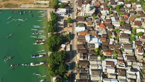Top-down-aerial-view-of-fishermen-village-at-Awang-fishing-harbour,-many-boats-at-the-seashore,-rooftop-homes-at-Island,-Lombok,-Mertak,-Indonesia