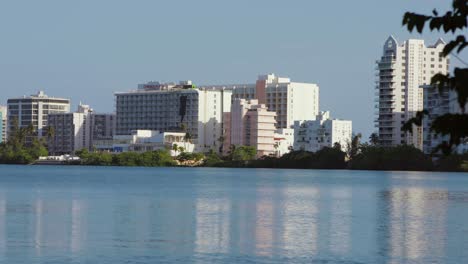 Hotels-and-resorts-in-Condado,-San-Juan,-Puerto-Rico-during-the-day-viewed-across-the-Laguna-del-Condado---Pan-Right