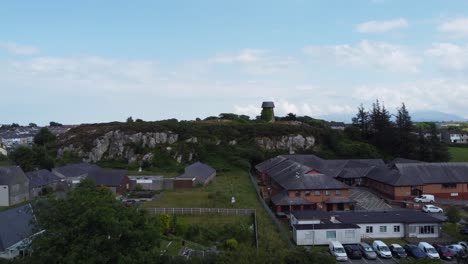Molino-De-Viento-Llangefni-En-Desuso-Cubierto-De-Hiedra-Vista-Aérea-Histórica-De-La-Ladera,-Anglesey