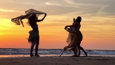 three-women-are-wonderfully-lost-in-the-dance-in-front-of-each-other-with-their-long-dupattas-flying-in-the-air-which-looks-very-sexy-against-the-backdrop-of-sea-waves-and-sunset