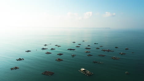 Many-floating-cages-for-fish-and-lobster-farming-at-Awang-Bay-fishing-harbour,-Lombok,-Mertak,-Indonesia