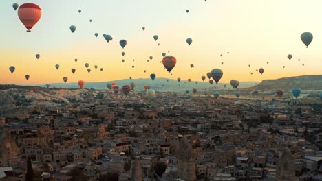 Standardaufnahme-Eines-Farbenfrohen-Heißluftballonfestivals-über-Einem-Tal-In-Kappadokien,-Türkei,-Mit-Vielen-Luftballons,-Die-Unten-Pfeifen-Und-Tausenden-Bunten-Luftballons-Darüber-Fliegen