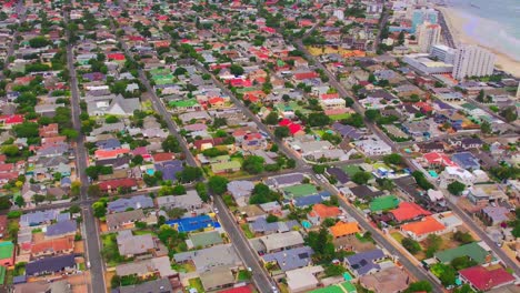 Establecer-Toma-Aérea-De-Ciudad-Del-Cabo,-Casas-Residenciales-Coloridas-Y-Camino-Limpio,-Cámara-Aérea-Avanzando-Vecindario-Entre-árboles-Otoñales-Al-Amanecer,-Vista-Aérea