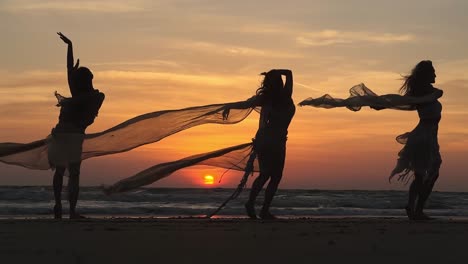 Three-foreign-sexy-women-doing-amazing-dance-with-their-hands-and-flexible-body,-dupatta-of-all-three-are-waving-in-the-air-and-sunrise-from-behind