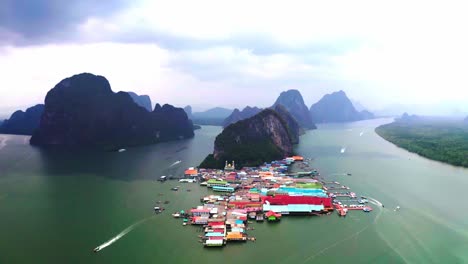 Panyee-floating-village-Aerial-drone-camera-moving-forward-showing-many-big-size-mountains-and-in-the-middle-is-this-village-which-is-colorful-and-floating-in-the-water