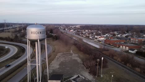 Township-of-Rockwood-with-steel-water-tower-and-highway-nearby,-aerial-drone-view