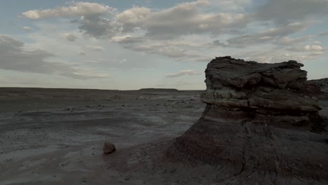 Pullback-aerial-reveal-of-eroded-buttes-in-a-barren-desert-landscape