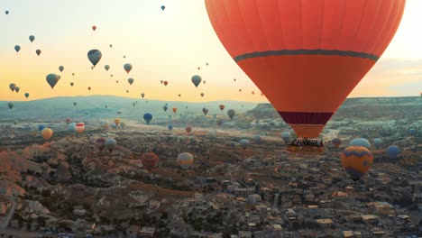 established-shot-in-which-thousands-of-colorful-hot-air-balloons-fly-over-the-city-of-Cappadocia,-Turkey,-captured-by-an-aerial-drone-camera,-Time-ramping-and-hyper-lapse-air-balloon-shots