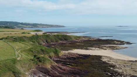 Traeth-Lligwy-Anglesey-eroded-coastal-shoreline-aerial-view-scenic-green-rolling-Welsh-weathered-countryside-coastline