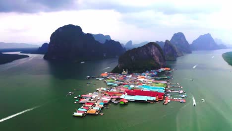 Panyee-floating-village-aerial-view-is-rotating-in-which-boats-and-boats-are-going-forward-in-the-water-and-floating-houses-are-visible-in-the-colorful-water