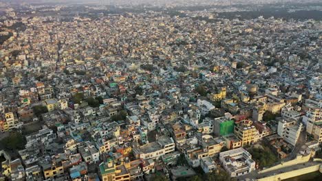 Aerial-drone-camera-flying-over-Udaipur-city-showing-millions-of-color-full-residential-houses-in-the-middle-of-a-fort-showing-Amazing-and-Incredible-India