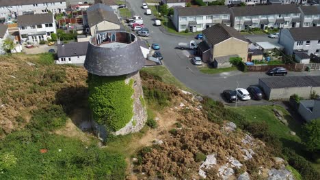 Melin-Wynt-Y-Craig-hilltop-Llangefni-windmill-ivy-covered-landmark-aerial-view-circling-above-old-mill