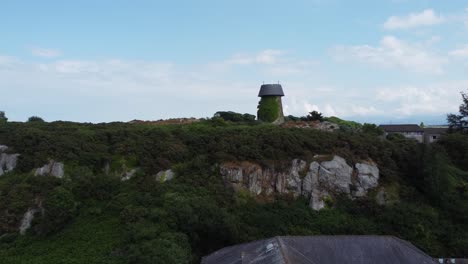 Melin-Wynt-Y-Craig-Stillgelegte-Llangefni-Windmühle,-Mit-Efeu-Bedecktes-Wahrzeichen-Am-Hang,-Luftaufnahme,-Anglesey