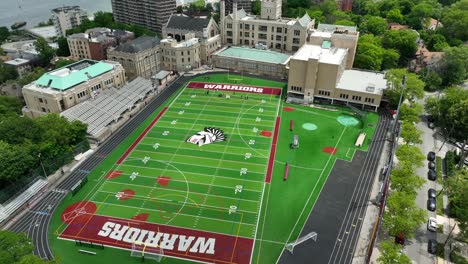 Toma-Aérea-En-órbita-Del-Campo-De-Fútbol-De-Los-Guerreros-Vacío-En-Staten-Island-Con-El-Horizonte-De-La-Ciudad-De-Nueva-York-En-El-Fondo---Toma-Inclinada-Hacia-Arriba