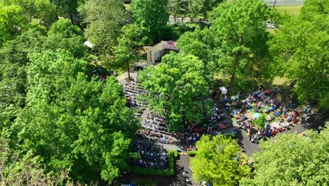 Drone-footage-of-an-outdoor-church-service-in-a-park,-children's-choir-and-Sunday-devotional