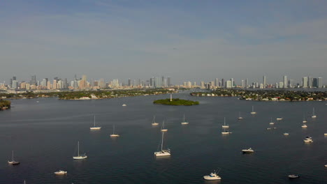 Rising-drone-shot-of-yachts-and-boats-in-harbor-with-Miami-skyline-in-background