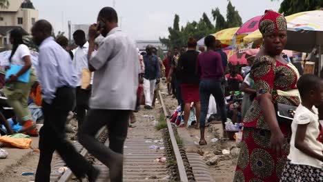 Crowded-market-people-crossing-raiway-in-Lagos,-Nigeria