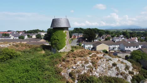 Llangefni-windmill-ivy-covered-landmark-aerial-view-pull-back-reveal-rural-welsh-monument