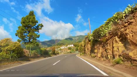 Impresionante-Viaje-Por-La-Sinuosa-Carretera-De-Montaña,-Desde-La-Perspectiva-Del-Conductor,-Rodeado-De-Majestuosas-Montañas-Y-Vegetación-Verde,-Parque-Nacional-Del-Teide,-Tenerife,-Islas-Canarias,-España,-Europa
