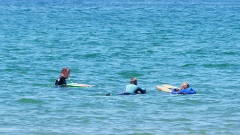 Healthy-lifestyle-active-seniors-paddle-boarding-and-chatting-together-on-turquoise-welsh-waves