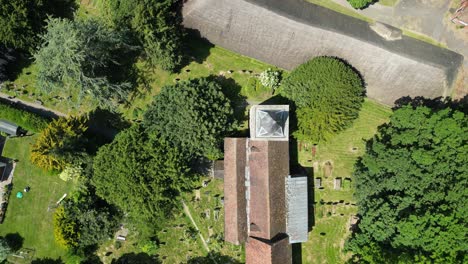 High-altitude-drone-flying-over-a-village-church-with-orange-roof-tiles