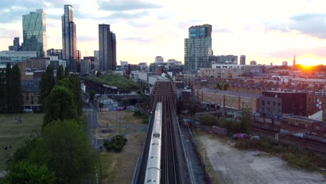 Static-drone-shot-train-travelling-on-railway-through-city-in-Britain