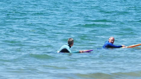 Healthy-active-seniors-in-retirement-paddle-boarding-and-chatting-together-on-turquoise-welsh-waves
