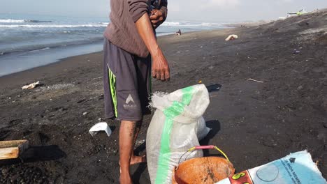 Trabajador-Tradicional-Recoge-Piedras-Trabajo-Cultural-En-La-Playa-En-Bali-Indonesia,-Recogiendo-Guijarros