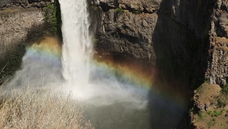 Brilliant-rainbow-forms-in-waterfall-mist-at-bottom-of-rocky-canyon