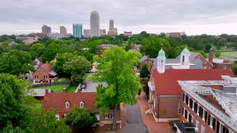 Aerial-pullout-from-Old-Salem-NC,-North-Carolina-with-Winston-Salem-Skyline-in-the-background