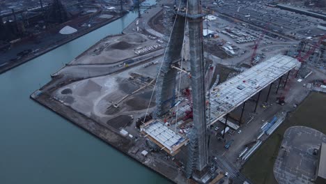 Concrete-pillar-of-massive-Gordie-Howe-bridge,-aerial-drone-view-of-construction-site