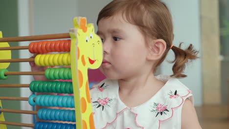 Cute-little-girl-counting-on-abacus---closeup-slow-motion