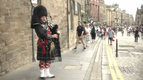 Sumérgete-En-La-Atmósfera-Vibrante-Mientras-Un-Hombre-Con-El-Traje-Tradicional-Escocés-Hipnotiza-A-La-Multitud-Tocando-La-Gaita-En-La-Icónica-Royal-Mile-De-Edimburgo.