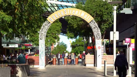 Daytime-view-of-Queen-street-mall-archway-sign-with-large-crowds-of-locals,-students,-tourists-and-workers-walking-and-strolling-at-the-outdoor-pedestrian-shopping-mall-at-downtown-Brisbane-city