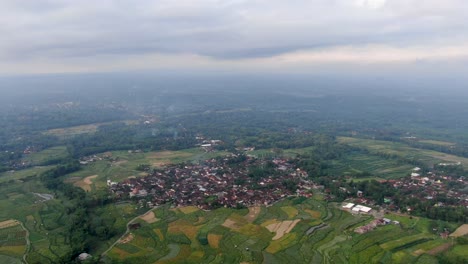 Small-township-in-vast-Indonesia-landscape,-aerial-drone-view