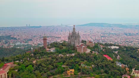 Aerial-drone-4K-footage-of-Tibidabo-in-Barcelona,-showcasing-the-majestic-mountain,-iconic-amusement-park,-and-panoramic-views