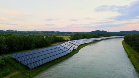 Captivating-aerial-4K-drone-footage-of-a-solar-panel-plant-nestled-alongside-the-Drava-river-in-Slovenia