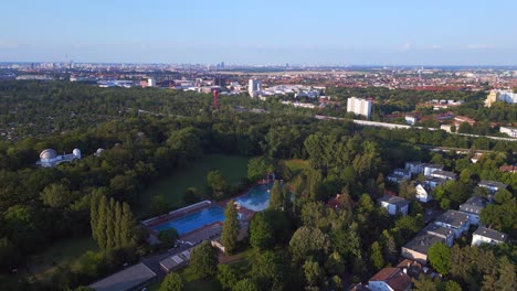 Dramatic-aerial-top-view-flight-Berlin-city-Public-swimming-pool-Germany-in-Europe,-summer-day-2023