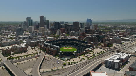 Downtown-Denver-Coors-field-Colorado-Rockies-baseball-stadium-Rocky-Mountain-landscape-Mount-Evans-aerial-drone-cinematic-foothills-Colorado-cars-traffic-spring-summer-backwards-movement