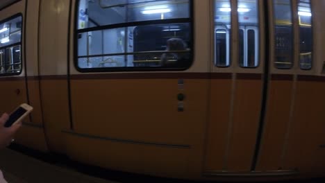Tram-on-line-2-Arriving-to-the-station-of-MÜPA--National-Theatre-at-night,-POV-of-scanning-the-e-ticket-QR-Code-on-a-phone-and-entering---Budapest,-June-2023