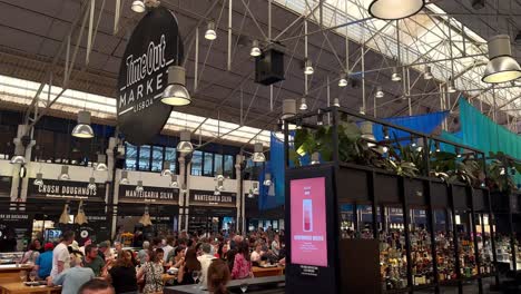 Slow-motion-shot-of-famous-Time-Out-Market-inside-hall-in-Lisboa-city-with-many-people-and-tourist---Medium-panning-shot